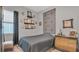 Neutral Bedroom with a black comforter, accent wall with geometric decoration, and wood floors at 8677 Bridgeport Bay Cir, Mount Dora, FL 32757