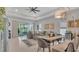 Bright living room with a comfortable gray sofa, modern lighting, and access to the lanai at 8677 Bridgeport Bay Cir, Mount Dora, FL 32757