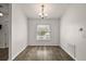 Dining area with a window, chandelier and wood-look flooring at 8721 Se 159Th Pl, Summerfield, FL 34491