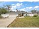 Well-manicured front lawn and charming gray house featuring a two-car garage with a white fence in the background at 8721 Se 159Th Pl, Summerfield, FL 34491