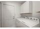 Laundry room featuring white washer and dryer and hanging cabinets at 8721 Se 159Th Pl, Summerfield, FL 34491