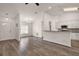 Open-concept living room with wood-look flooring seamlessly connecting to kitchen and dining area at 8721 Se 159Th Pl, Summerfield, FL 34491