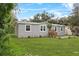 The side view of the house shows a green yard and additional building on the property at 909 Lake Thomas Rd, Lake Wales, FL 33898