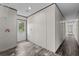 Hallway with gray wood-look flooring, and a bright white door with glass inset for natural light at 909 Lake Thomas Rd, Lake Wales, FL 33898