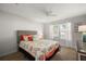 Bright bedroom featuring charming coastal decor, ceiling fan, and a large window at 9243 Se 171St Cooper Loop, The Villages, FL 32162