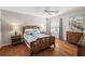 Well-lit bedroom with ceiling fan, wood floors and nautical themed decor at 9243 Se 171St Cooper Loop, The Villages, FL 32162