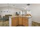 View of the kitchen island with granite countertops overlooking the dining and living spaces at 9243 Se 171St Cooper Loop, The Villages, FL 32162