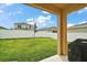 Backyard view from patio showing green lawn, grill, and a privacy fence at 3040 Tansy St, Tavares, FL 32778