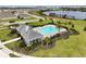 Aerial view of a beautiful community pool, clubhouse, and lush landscaping near a serene lake in Avalon Park at 3040 Tansy St, Tavares, FL 32778