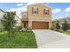 Charming two-story home featuring a brown two-car garage and beautifully landscaped front yard at 3040 Tansy St, Tavares, FL 32778