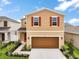 Front exterior showing a two-story home with a two car garage and lawn at 3040 Tansy St, Tavares, FL 32778