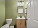 Well lit half bathroom featuring sage walls, a modern vanity, and neutral decor at 3040 Tansy St, Tavares, FL 32778