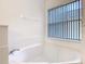 Bathroom featuring a large bathtub underneath a window at 1007 Balmoral Dr, Davenport, FL 33896