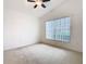 Vaulted bedroom featuring neutral carpet, ceiling fan, and a large window allowing natural light at 1007 Balmoral Dr, Davenport, FL 33896