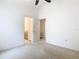 Bright bedroom featuring neutral carpet, ceiling fan, and access to an ensuite bathroom and closet at 1007 Balmoral Dr, Davenport, FL 33896