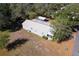 Aerial view of house showcasing metal roof, surrounding foliage and driveway at 11642 Martell Ct, Leesburg, FL 34788