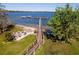 Aerial view of a dock on the water with a beach and fire pit, offering a serene coastal ambiance at 11642 Martell Ct, Leesburg, FL 34788