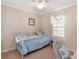 Bedroom with a bed, window, ceiling fan, and wicker chair at 11642 Martell Ct, Leesburg, FL 34788