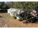 Aerial view of charming single-story home with a screened-in porch and metal roof at 11642 Martell Ct, Leesburg, FL 34788