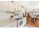 Bright kitchen featuring white appliances, ample counter space and cabinetry with a view of the dining area at 11642 Martell Ct, Leesburg, FL 34788