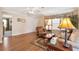 Living room with wood floors, ceiling fan and a comfortable seating area at 11642 Martell Ct, Leesburg, FL 34788