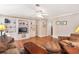 Living room with wood floors, built in shelving and cabinets, and a ceiling fan at 11642 Martell Ct, Leesburg, FL 34788