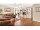 Spacious living room featuring wood floors, a built-in entertainment center and access to the dining room at 11642 Martell Ct, Leesburg, FL 34788