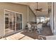 Covered patio features a ceiling fan, outdoor seating, and sliding glass doors to the home's interior at 11642 Martell Ct, Leesburg, FL 34788