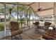 Screened porch with a ceiling fan, dining table and seating at 11642 Martell Ct, Leesburg, FL 34788