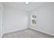 Bright bedroom featuring neutral carpeting, white walls and trim, and a window with outside view at 1193 Stratton Ave, Groveland, FL 34736