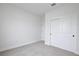 Neutral bedroom featuring gray carpeting, white walls and trim, and closet with sliding doors at 1193 Stratton Ave, Groveland, FL 34736