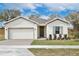 Charming single-story home with a brick driveway, well-manicured lawn, and neutral-toned facade at 1193 Stratton Ave, Groveland, FL 34736