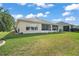 A serene backyard featuring well-maintained lawn and an enclosed porch at 11945 Se 91St Cir, Summerfield, FL 34491