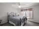 A well-lit bedroom featuring a metal bed frame, soft carpet, and a bright window at 11945 Se 91St Cir, Summerfield, FL 34491