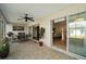 Relaxing covered lanai featuring a ceiling fan, tile flooring, and sliding glass doors to both the living room and screened in patio at 11945 Se 91St Cir, Summerfield, FL 34491