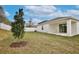 Spacious backyard with a newly planted tree and a white fence at 1197 Stratton Ave, Groveland, FL 34736