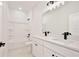 Bathroom featuring dual sinks, a white tub and shower combination, and modern black fixtures at 1197 Stratton Ave, Groveland, FL 34736