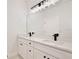 Bright bathroom with white cabinets, double vanity, and black modern fixtures at 1197 Stratton Ave, Groveland, FL 34736