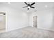 A bright bedroom features neutral carpet, a ceiling fan, and a walk-in closet at 1197 Stratton Ave, Groveland, FL 34736