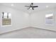 A well-lit bedroom with neutral carpeting and a modern ceiling fan at 1197 Stratton Ave, Groveland, FL 34736