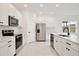 Bright kitchen with stainless steel appliances, white cabinetry, and a stylish faucet at 1197 Stratton Ave, Groveland, FL 34736