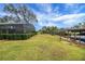 Expansive backyard featuring screened lanai and boat dock at 12338 S Putney Ct, Leesburg, FL 34788