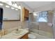 Bathroom featuring tiled walls, a framed shower and tub combo, and a vanity with a mirror at 12338 S Putney Ct, Leesburg, FL 34788