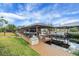 View of the covered boat dock with seating area, providing access to the waterway at 12338 S Putney Ct, Leesburg, FL 34788