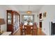 Well-lit dining room with hardwood floors, china cabinet, and view of the pool at 12338 S Putney Ct, Leesburg, FL 34788