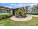 Lovely home exterior with stone accents, lush landscaping, and circular driveway at 12338 S Putney Ct, Leesburg, FL 34788