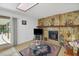 Living room with fireplace and sliding glass doors to lanai at 12338 S Putney Ct, Leesburg, FL 34788