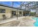 Screened-in patio featuring a pool, seating area, and tiled flooring at 12338 S Putney Ct, Leesburg, FL 34788