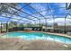 A beautiful in-ground pool is surrounded by a screened enclosure and a luxurious hot tub at 12338 S Putney Ct, Leesburg, FL 34788