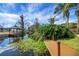 Picturesque waterfront view from the wooden dock with lush greenery and a covered boat dock at 12338 S Putney Ct, Leesburg, FL 34788